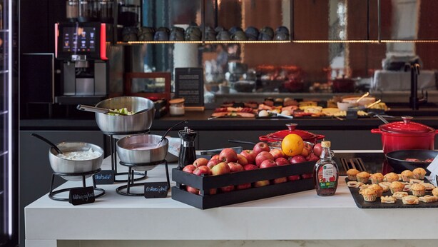 A buffet with various food items and a coffee station.