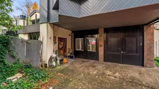 Ein modernes Haus mit Satteldach, Garage und umzäunter Rückseite.