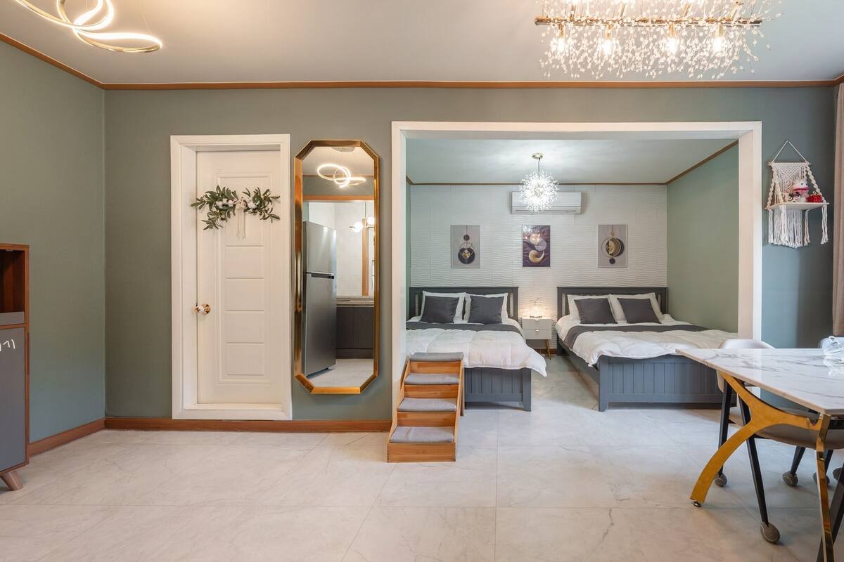 Habitación de hotel moderna con zona de comedor, cocina y baño.