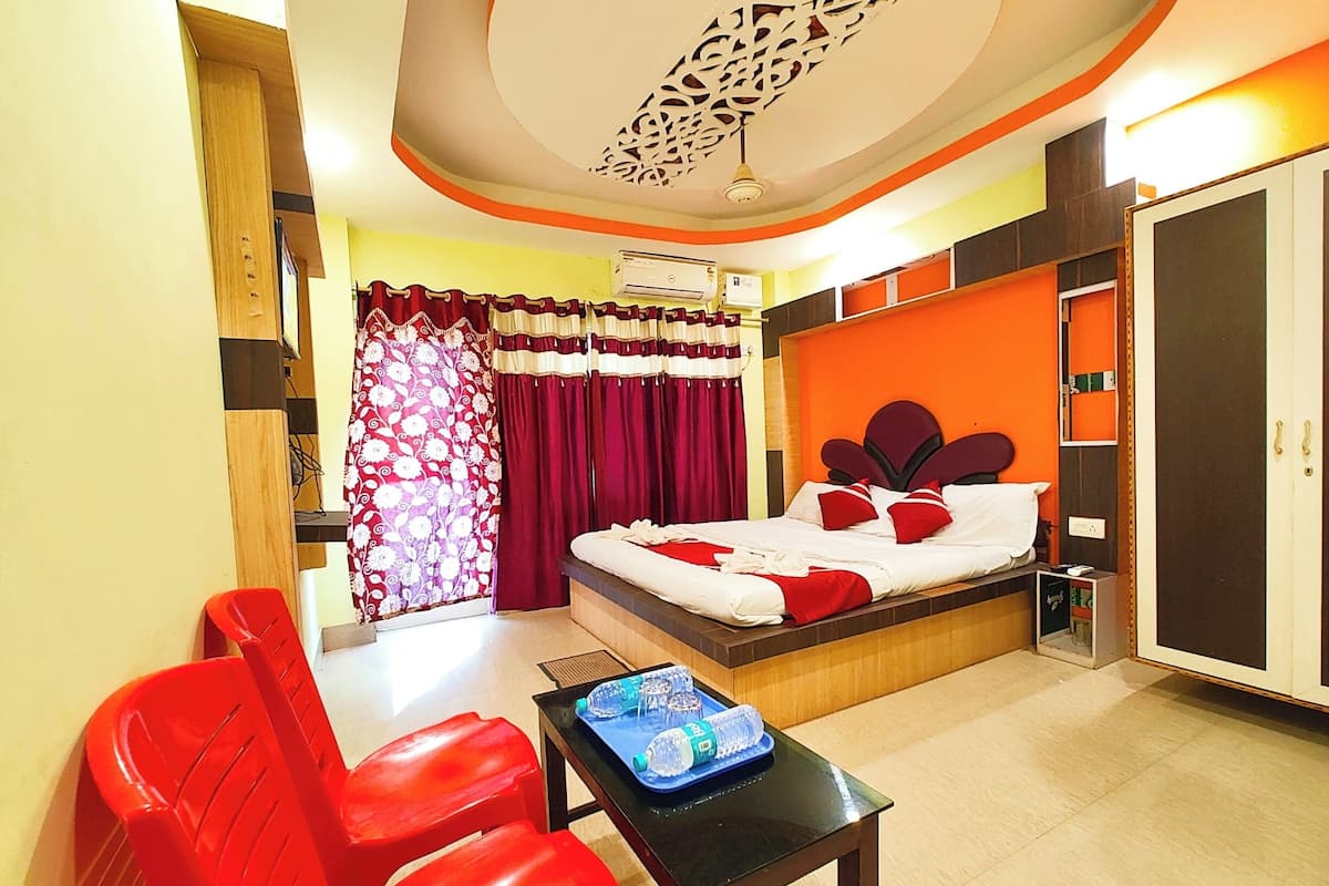 Une chambre d’hôtel avec un lit, un bureau, une chaise et une armoire.