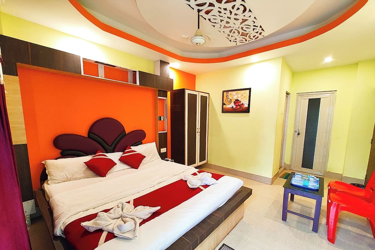 Une chambre d’hôtel avec un lit, une armoire, une porte et une petite table avec une chaise.