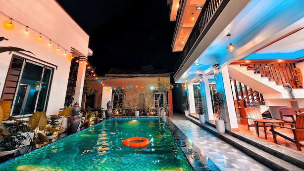 A swimming pool with a floating ring, surrounded by potted plants and outdoor furniture. - Tam Coc Homestay Thanh Thang (Nam Hoa Lu)