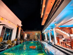 A swimming pool with a floating ring, surrounded by potted plants and outdoor furniture. - Tam Coc Homestay Thanh Thang (Nam Hoa Lu)