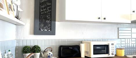 Een koffiezetapparaat/waterkoker, een koelkast, een magnetron, een oven