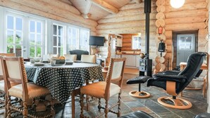 A cozy log cabin interior with a dining area, a fireplace, and a comfortable seating area. - "Mojag" - 900m from the sea by Interhome (Hirtshals)