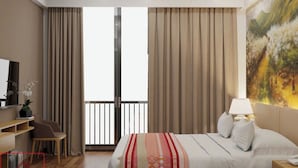 Une chambre d’hôtel moderne dotée d’un grand lit, d’un bureau, d’une chaise, d’une télévision et d’un balcon avec des rideaux.