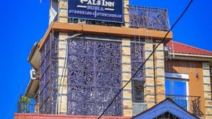 A building with a sign for 'Pals Inn' and a contact number.