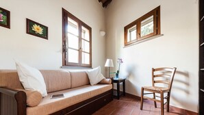 Ein gemütliches Zimmer mit einer Holzdavaya, einem Sessel und einem kleinen Tisch mit einer Lampe.