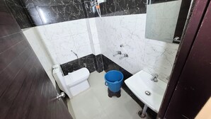 A bathroom with a toilet, sink, and shower. - RK Residency (Vrindavan)