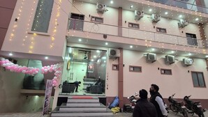 A multi-story building with balconies, air conditioning units, and a staircase leading to the entrance. - RK Residency (Vrindavan)