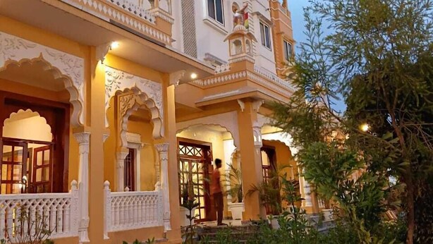 Un edificio tradicional con arcos ornamentales y un balcón, rodeado de follaje.