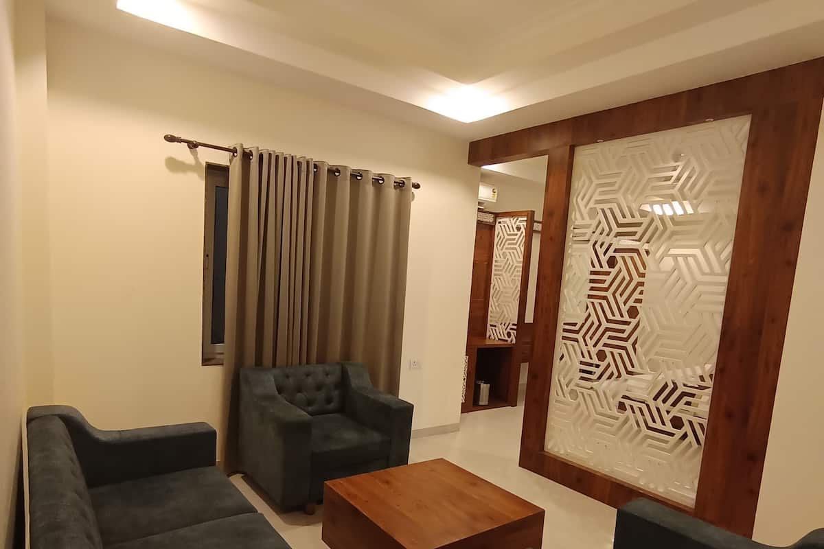 Una sala de estar moderna con un sofá modular, una mesa de centro de madera y un separador decorativo con diseños geométricos.