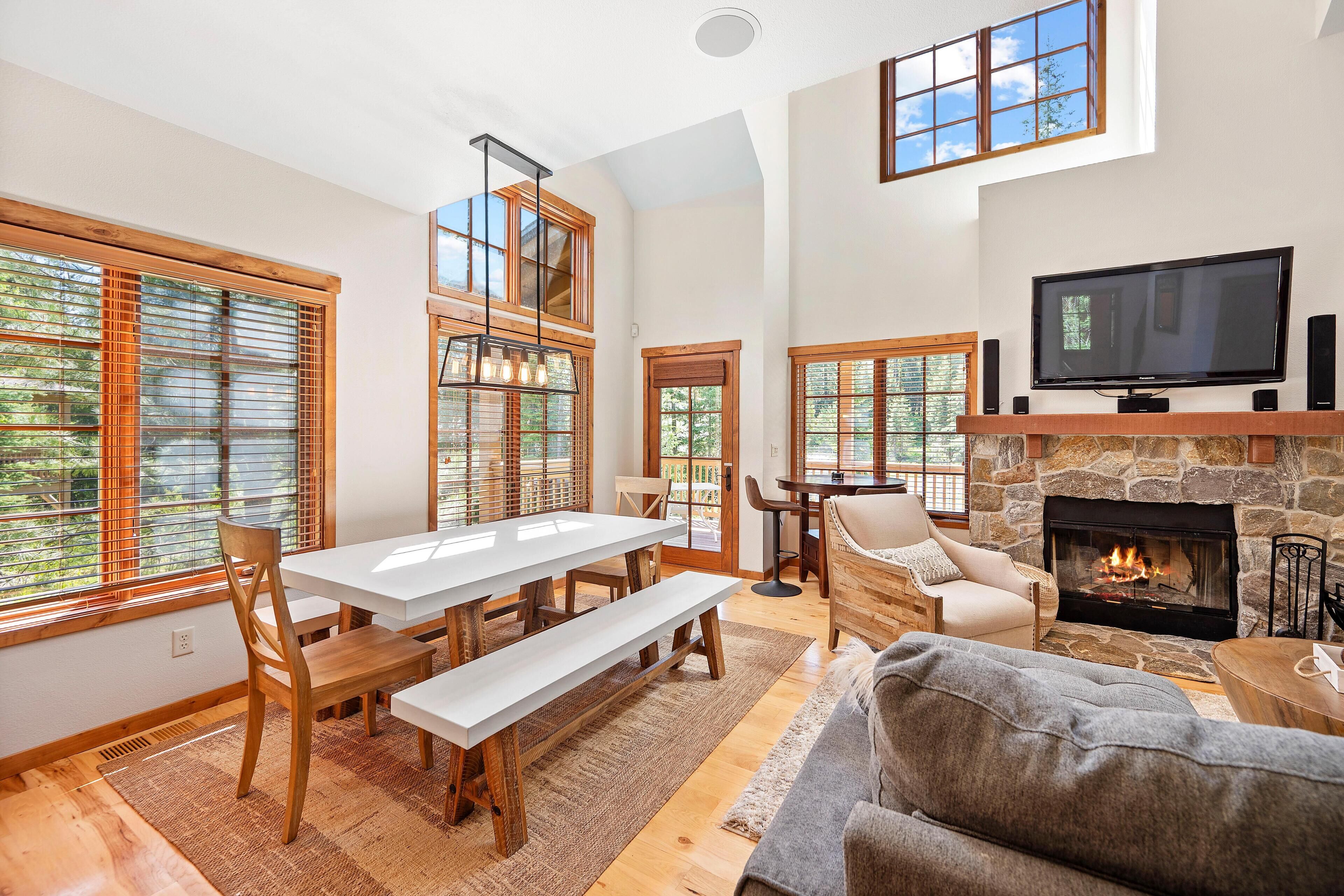 A spacious living area with a fireplace, a television, and a dining area with wooden furniture.
