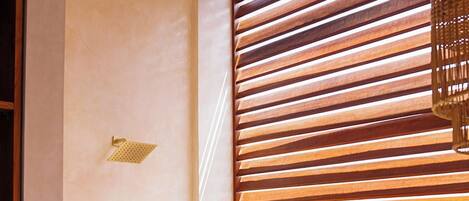 A bathroom with a wooden slat wall, a gold faucet, and a white sink.
