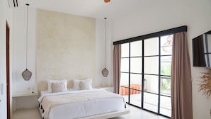 A bedroom with a bed, a large window, and a view of the outdoors. - Arrova Bali Berawa, Canggu by Sandara (Jimbaran)