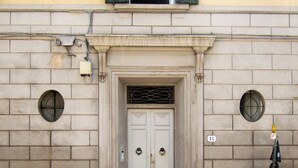 A building facade with a central door, two windows with shutters, and a small circular window above the door. - Bright 3 Bed Rooms Orti Oricellari (Florence)