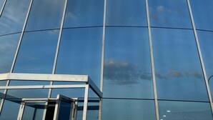 A modern hotel building with a clear sky and a flag. - Hospedium Hotel A Mar (Villafranca de los Barros)
