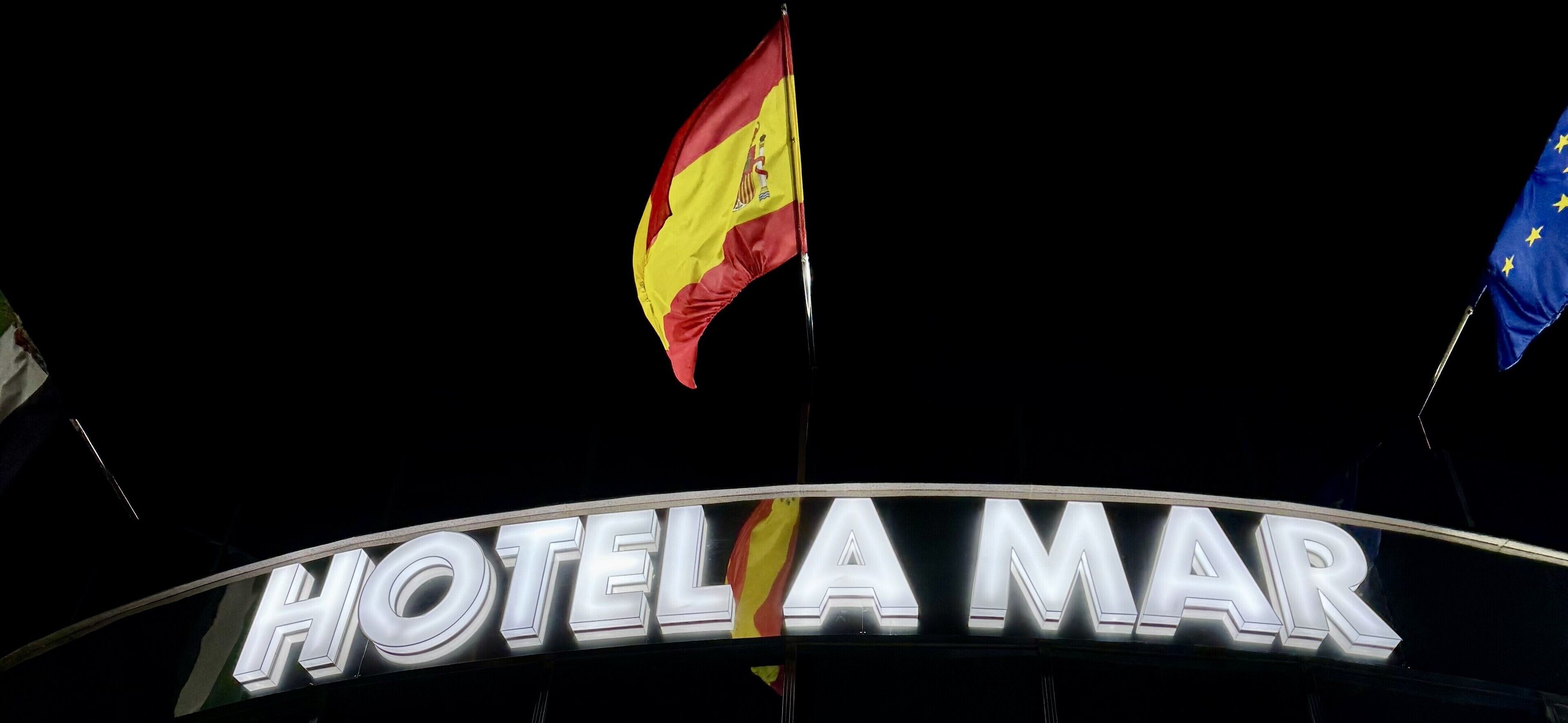 Segnaletica di un hotel con bandiere, tra cui la bandiera spagnola e quella dell'Unione Europea.
