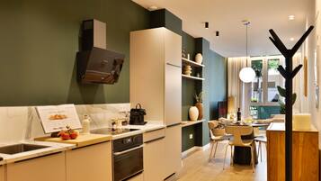 Una cocina moderna con horno integrado, un lavamanos y una zona de comedor con mesa y sillas.