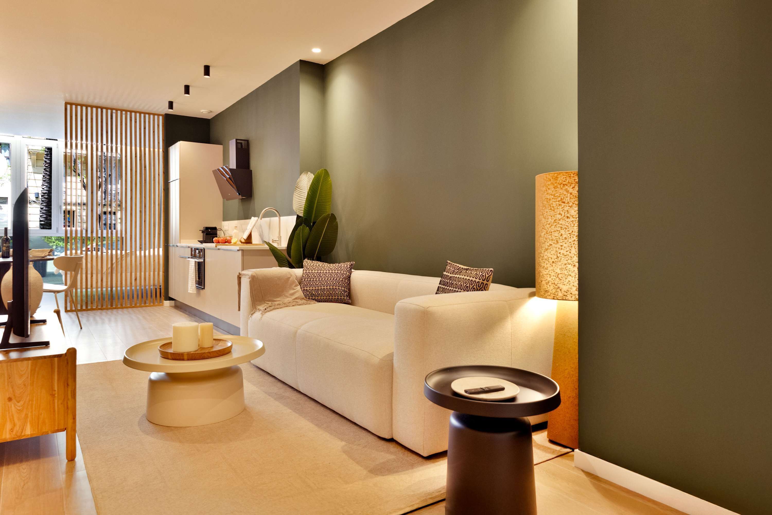 A modern living room with a beige sofa, a round coffee table, and a side table.