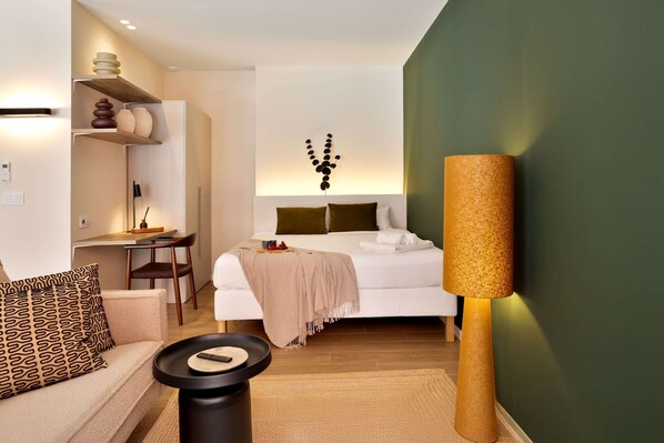 A modern hotel room with a bed, bedside table, lamp, and a desk with a chair. - SariStays VLC Modern Oasis Patio 6 (València)