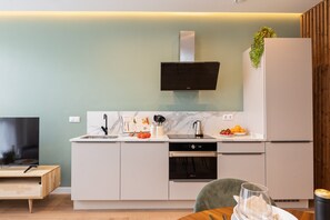 Une cuisine moderne équipée d’un four encastré, d’un four à micro-ondes et d’un évier en acier inoxydable.