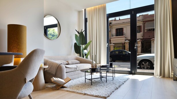 Un salon moderne avec un canapé, une table basse et une plante.