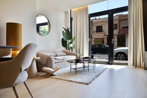Een moderne woonkamer met een bank, salontafel en een plant.