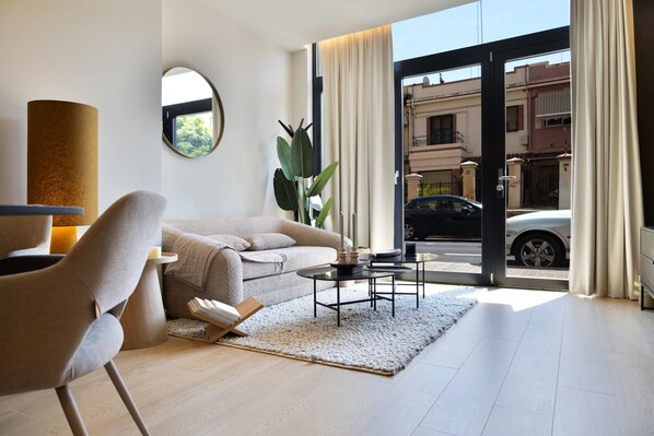 A modern living room with a sofa, coffee table, and a plant.