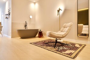 A modern bathroom with a freestanding bathtub, a chair, and a patterned rug. - SariStays Valencia Finca Verde R (Valencia)