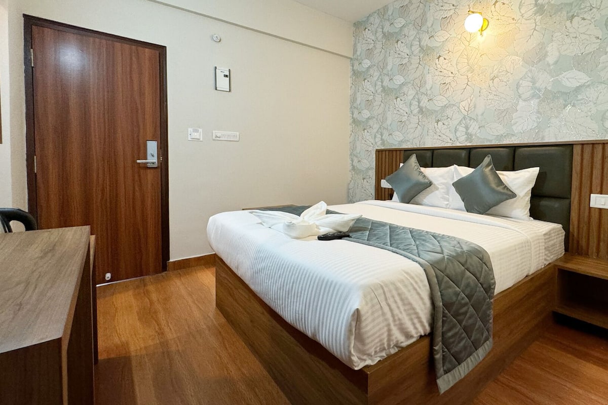 A neatly arranged bedroom with a bed, bedside table, and a chair.