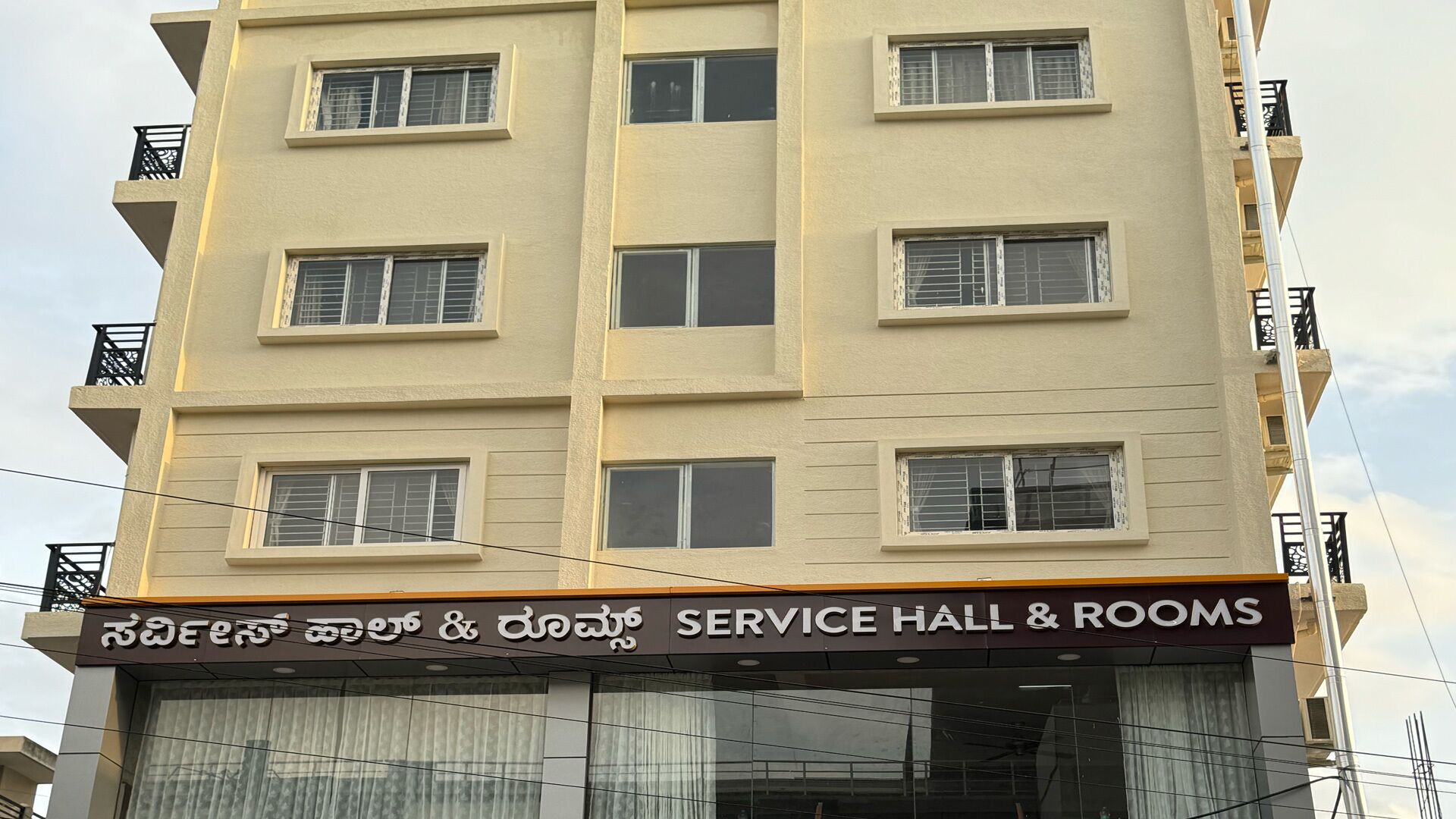 Un edificio de varios pisos con un letrero que dice "SERVICE HALL & ROOMS".