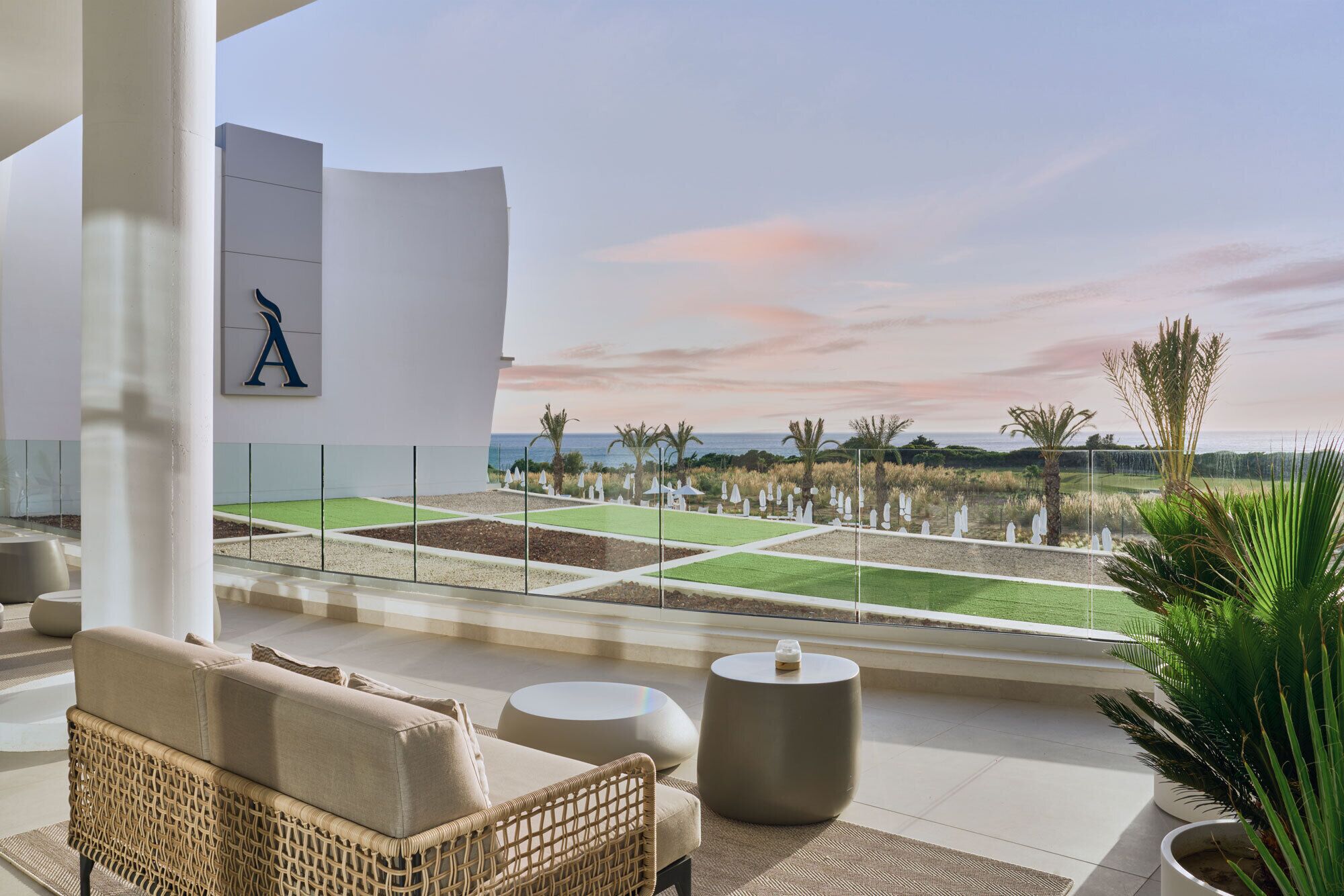 Un moderno espacio de relax con vistas a un campo de golf y al océano.