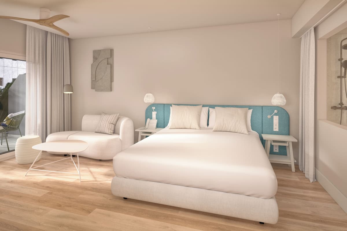 Quarto moderno com uma cama grande, um sofá pequeno, uma mesa de cabeceira e uma luminária.