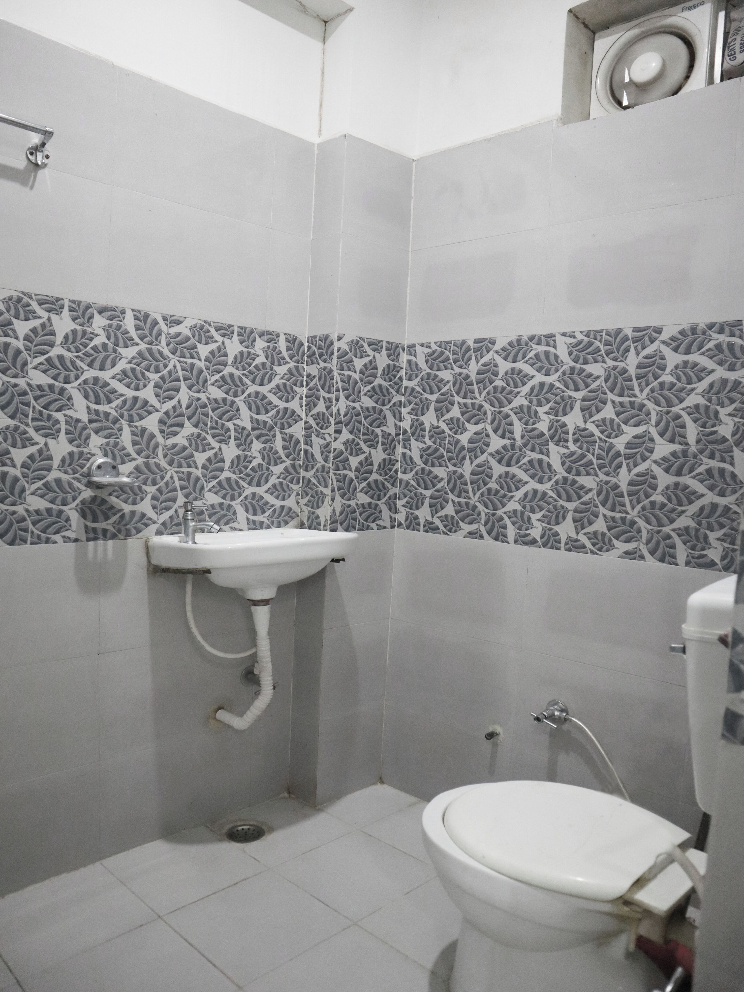 A bathroom with a toilet, a sink, and a shower area.