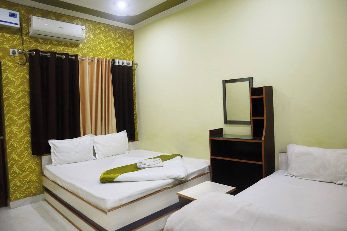 Una habitación de hotel con una cama, un escritorio y un espejo.