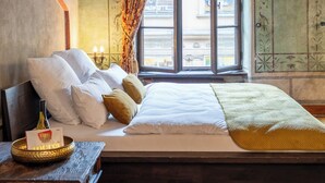 Une chambre traditionnelle avec un lit en bois, une table de chevet, un tapis en fourrure et une fenêtre avec des rideaux.