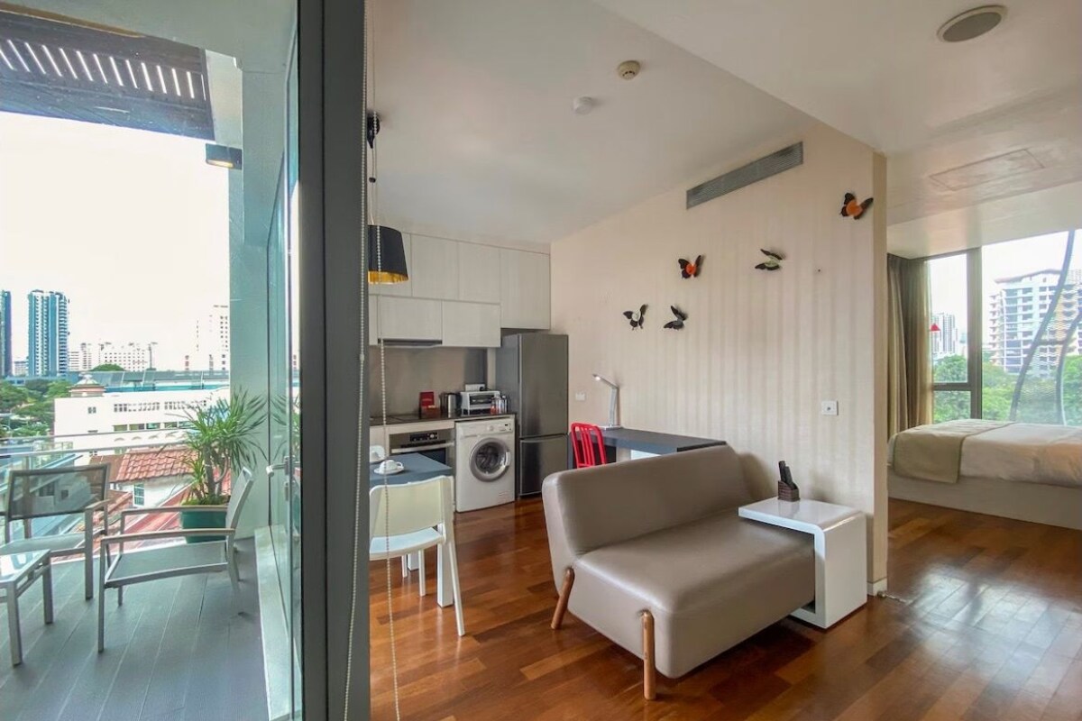 Ein modernes Apartment mit Küche, Essbereich und einem Balkon.