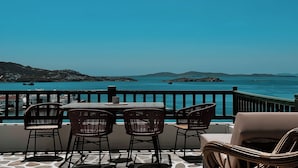 Una terraza con mesa y sillas con vistas a la costa.