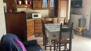 Une cuisine compacte avec des meubles en bois, un four à micro-ondes et une table à manger avec des chaises.