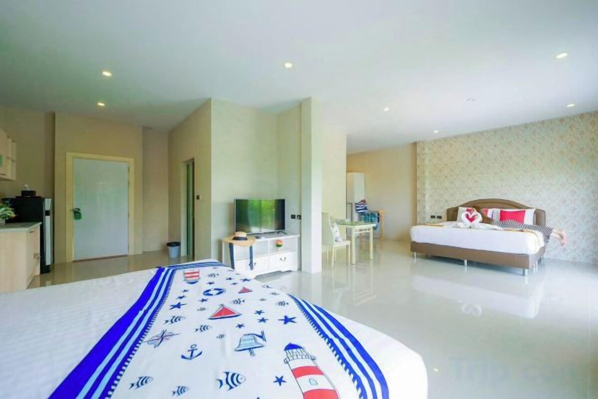 A hotel room with a bed, a television, a desk, and a chair.