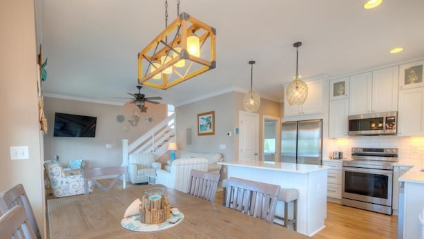 A spacious kitchen with white cabinets, stainless steel appliances, and a central island.