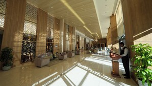 A spacious lobby with a high ceiling, wooden paneling, and a reception desk. - Casa Di Ora Hotel Al Rawdah (Jeddah)