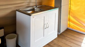 A compact kitchenette with a sink, cabinets, and a small refrigerator. - Floating Home in Reef Resort Unit 11 (Samal)
