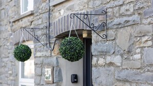 A stone building with a window and a door.