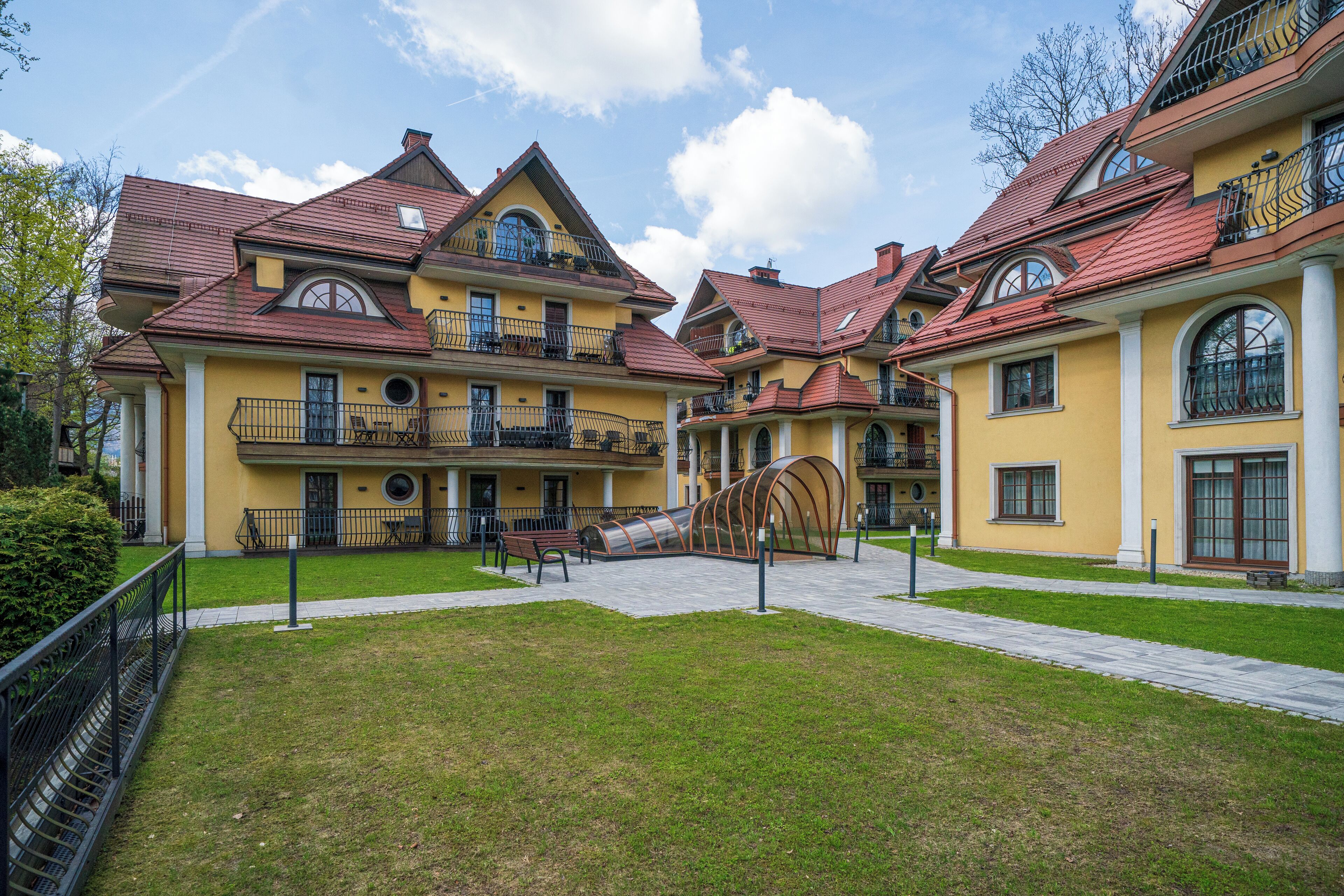 A yellow building with multiple balconies and a central courtyard.