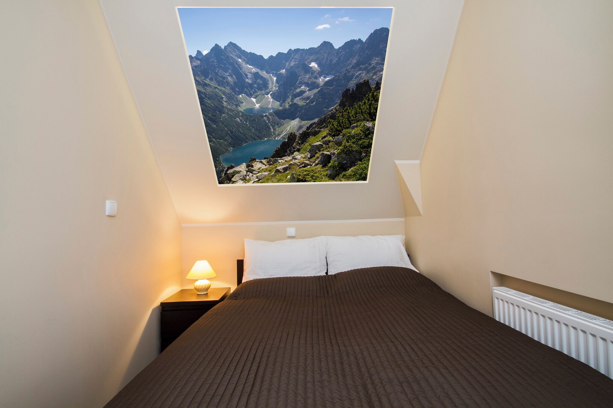 A bedroom with a large window overlooking a mountainous landscape.