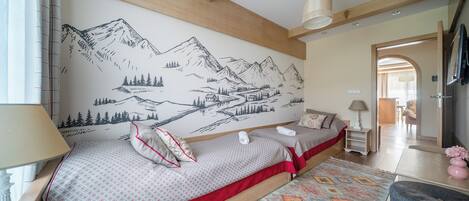 Un dormitorio con cama, mesita de noche, lámpara, cómoda y un mural en la pared.