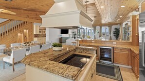 A modern kitchen with granite countertops, a built-in stove, and wooden cabinetry. - Turtle Crawl on Long Key Oceanfront Beachfront with dock and pool (Long Key)