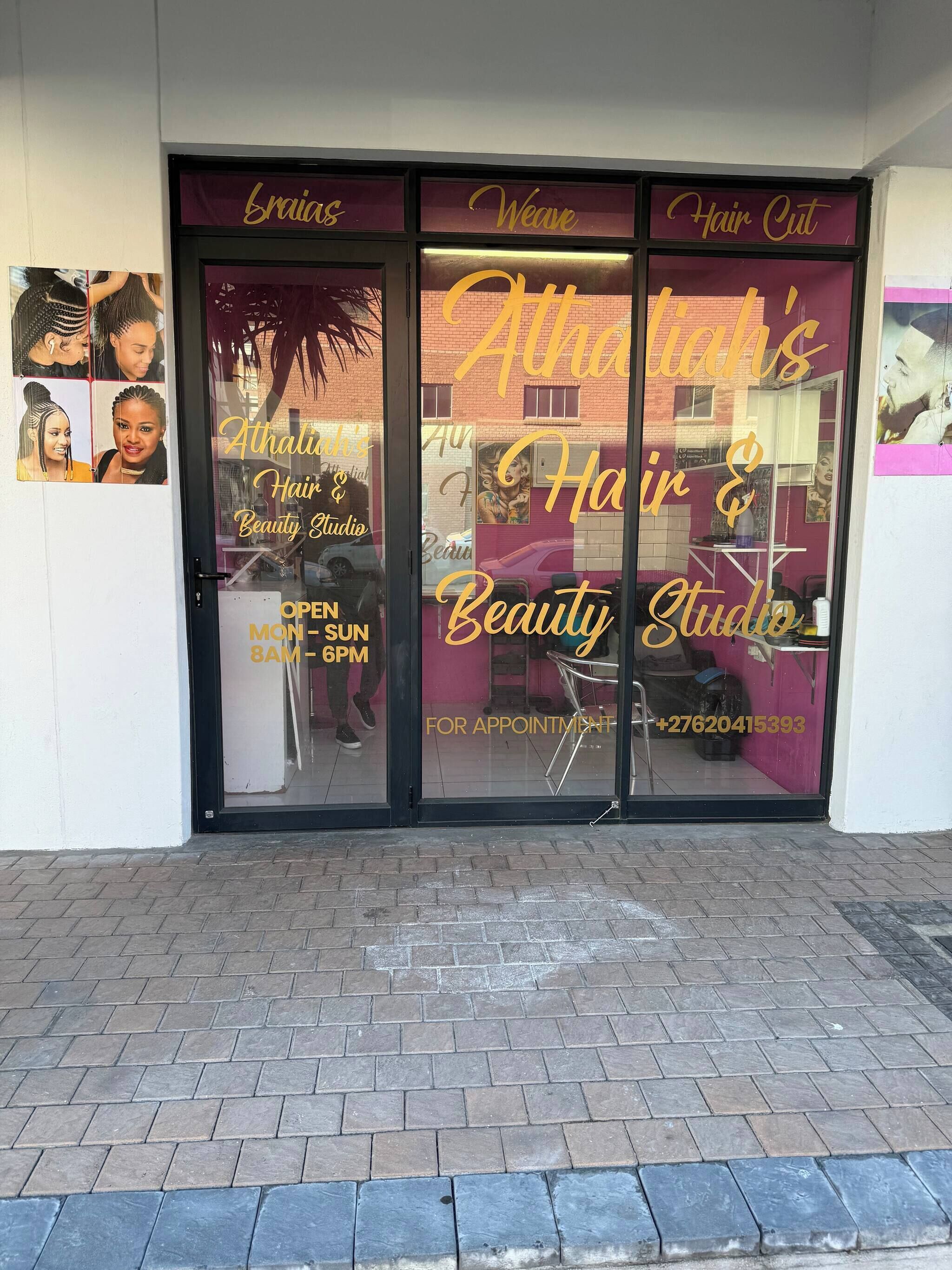 Un salon doté d’une porte vitrée, sur laquelle on peut lire : « Athalia’s Hair & Beauty Studio » et « Ouvert du lundi au dimanche, de 8h à 18h ».